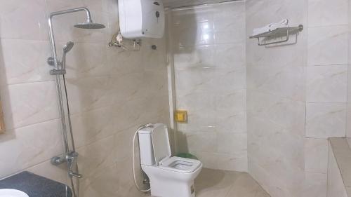 a bathroom with a toilet and a shower at New Way Hotel in Cat Ba
