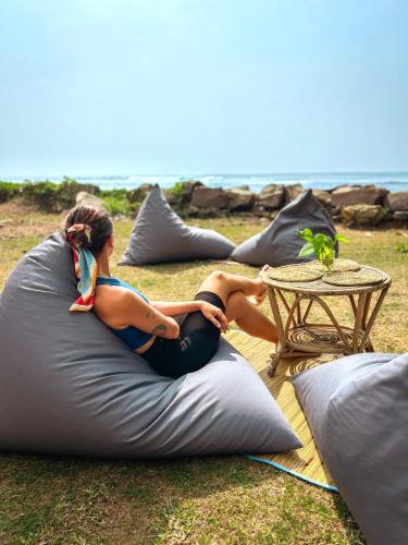 a woman sitting on a bean bag chair on the grass at Naïa Ocean House Midigama in Midigama West