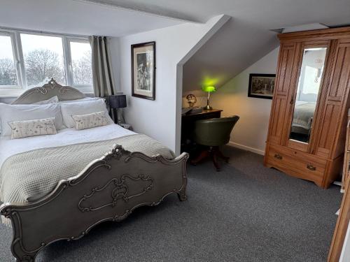 a bedroom with a bed and a desk and window at Abbey view in Selby