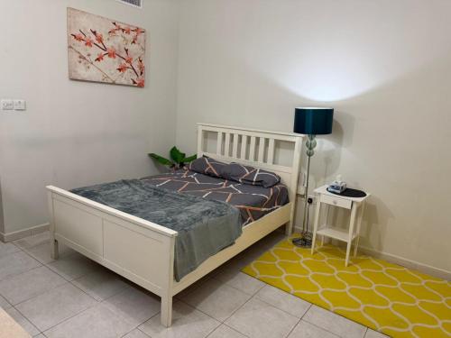 a bedroom with a bed and a table with a lamp at Studio Room with Private Bathroom & kitchen in Abu Dhabi