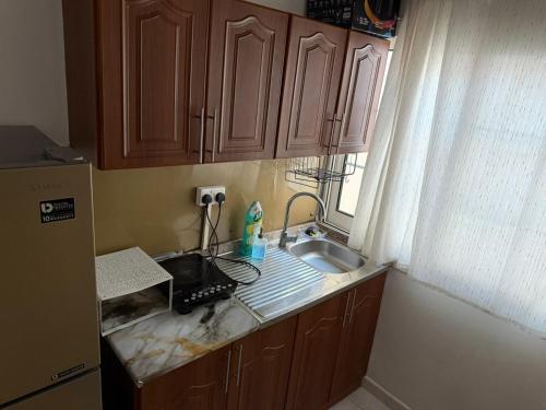 a kitchen counter with a sink and a window at Studio Room with Private Bathroom & kitchen in Abu Dhabi