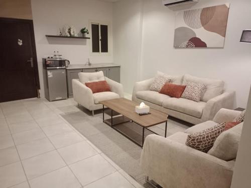 a living room with two couches and a coffee table at شقق أريز ستاي in Al Hada
