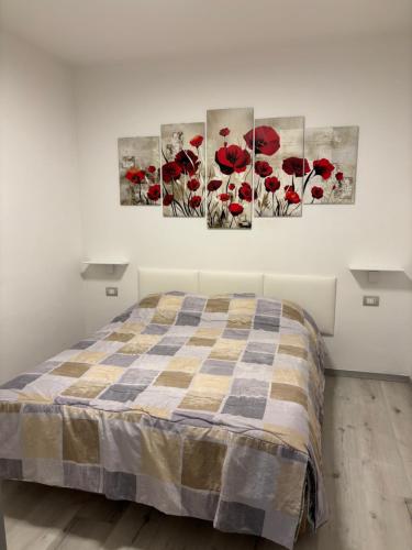 a bedroom with red poppies paintings on the wall at Giuly House in Arco