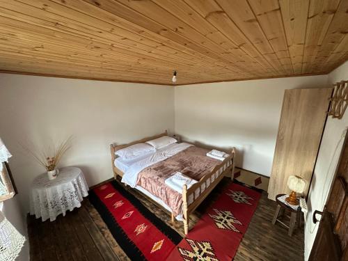 a bedroom with a bed and a wooden ceiling at Mark Toma Guesthouse in Shpor