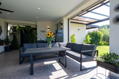 a patio with a table and a couch and a vase of flowers at Private Pool Villa by the Sea in Kalamata