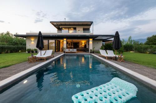 a house with a swimming pool in front of a house at Private Pool Villa by the Sea in Kalamata