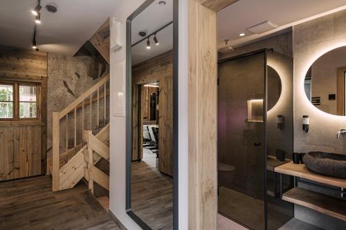 a bathroom with a glass door leading to a staircase at BRUGGER ApartHotel in Mayrhofen