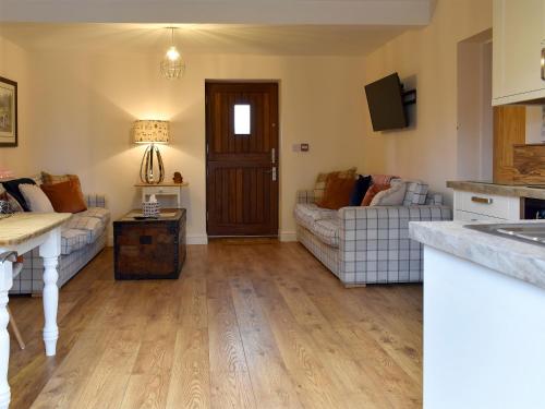 a living room with two couches and a kitchen at Sparrow - Uk30747 in Acton Trussell