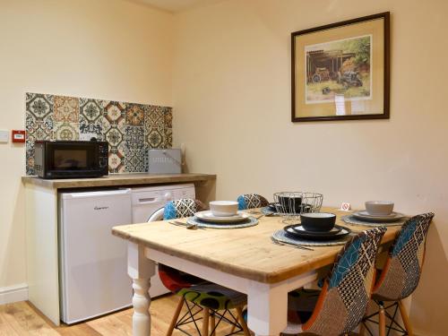 a kitchen with a table with chairs and a microwave at Sparrow - Uk30747 in Acton Trussell