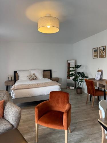 a bedroom with a bed and a chair and a table at DOMITYS - Les Belles Lettres in Herblay