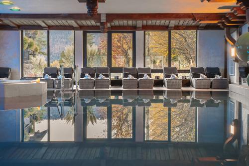 a room with a pool with a bunch of chairs at Alpin & Wellness Resort Ludwig Royal in Oberstaufen