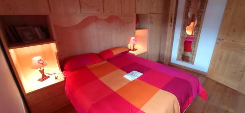 a bedroom with a large bed with a colorful blanket at Tabià Fregona, Chalet Alpino con vista e stile tradizionale in Fregona