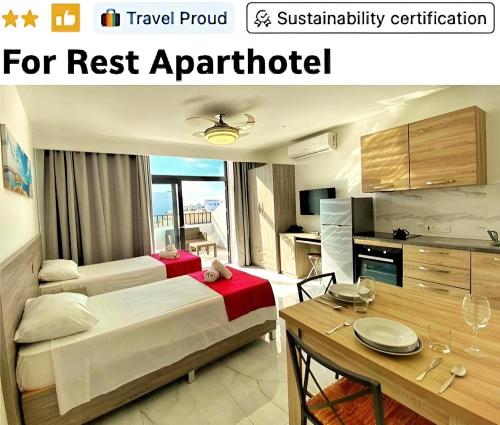 a hotel room with a bed and a table and a kitchen at For Rest Aparthotel in St. Paul's Bay