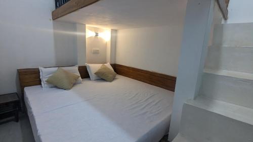 a small bedroom with a bed with white sheets and pillows at Bird Park Villa Ella in Ella