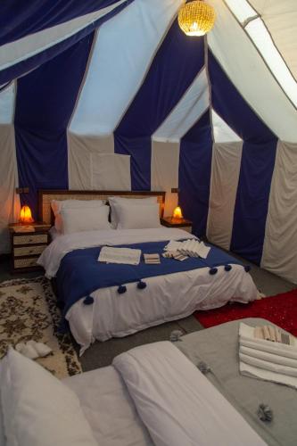 a bedroom with two beds in a tent at Khamlia Desert Camp in Merzouga