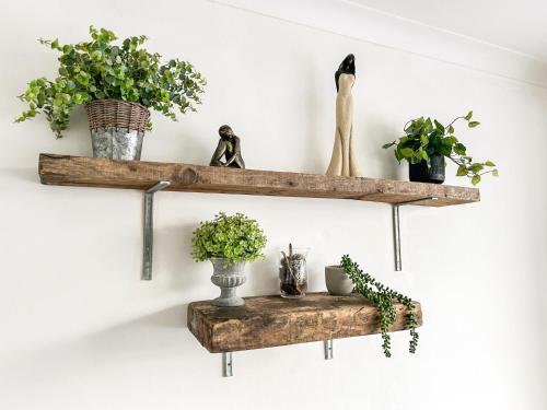 a pair of wooden shelves with plants on a wall at Highcross in Poulton le Fylde