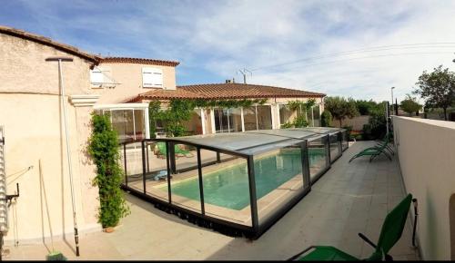 a house with a swimming pool in front of a house at Le Clos des Galets in Meynes
