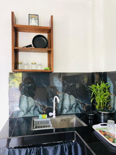 a kitchen sink with a faucet on a counter at Coco Breeze Villa in Talpe