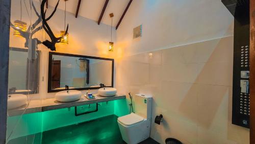 a bathroom with two sinks and a mirror and a toilet at Euro Elephant Yala in Tissamaharama