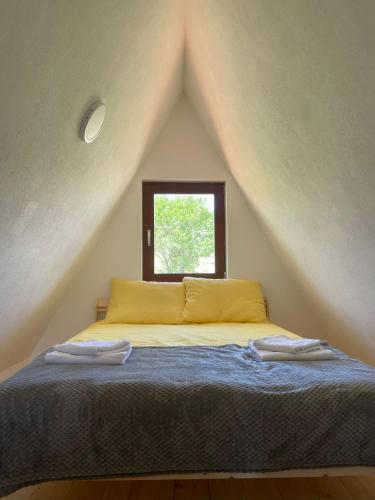 a bedroom with a bed in the attic with a window at The Tara Concept in Šljivovica
