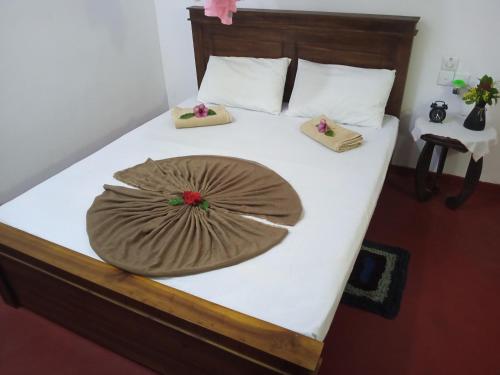 a large bed with a brown pillow on it at Breeze House in Hikkaduwa