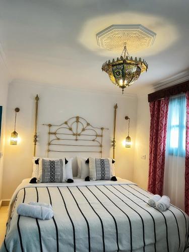 a bedroom with two beds and a chandelier at Riad Dar Home in Tétouan