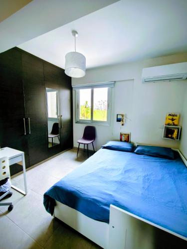 a bedroom with a large blue bed and a desk at Harmonia Home in Paralimni