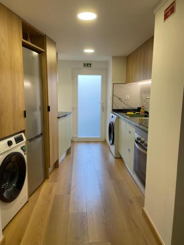 a large kitchen with a washer and dryer at Casa Catalão in Montelavar