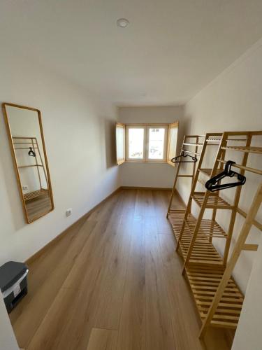 an empty room with wooden floors and two wooden shelves at Casa Catalão in Montelavar