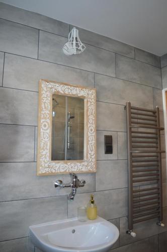 a bathroom with a sink and a mirror at Mojone Izby in Maruszyna