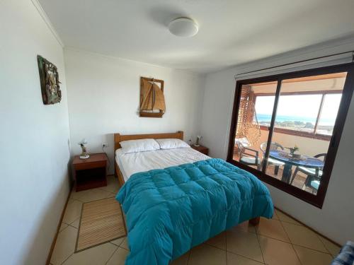 a bedroom with a bed and a large window at Cabañas Bellavista del mar in De Cauquenes