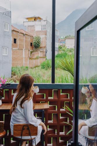 a little girl sitting at a table looking out a window at TITANIUM 9 Villa in Tlekung
