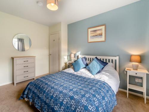 a bedroom with a bed and a dresser and a mirror at Arosfa in St. Davids