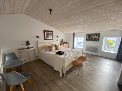 a bedroom with a white bed and a wooden ceiling at Chez Isabelle et Johann in Angliers