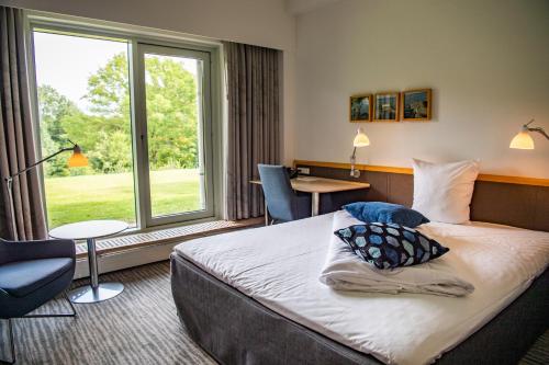 a hotel room with a bed and a window at KolleKolle Konferencehotel in Værløse