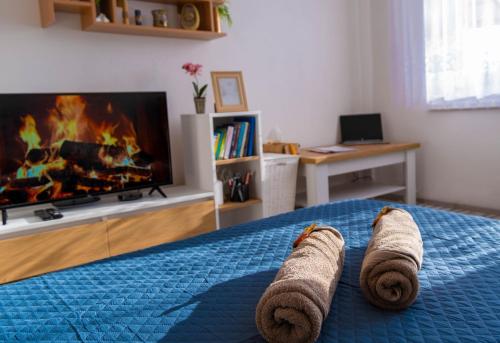 a bedroom with a bed with towels on it with a fireplace at LM Apartman in Spišská Nová Ves