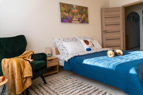 a bedroom with a bed and a chair at LM Apartman in Spišská Nová Ves