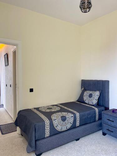 a bedroom with a bed with a blue bedspread at Sunset Vibes Larache in Larache