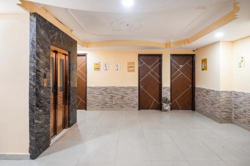 a hallway of a building with doors and tile floors at Itsy Hotels Saina Stay Near 32 Milestone in Gurgaon