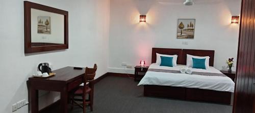 a hotel room with a bed and a desk and a desk at bansri villa in Mount Lavinia