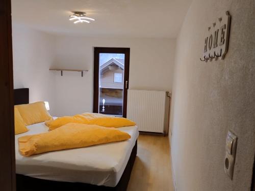 a bedroom with a bed with yellow pillows on it at Haus Heimat & Appartement in Huben