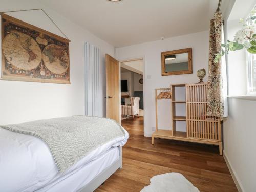 ein Schlafzimmer mit einem Bett und einem Holzboden in der Unterkunft Parkfields Cottage in Uttoxeter
