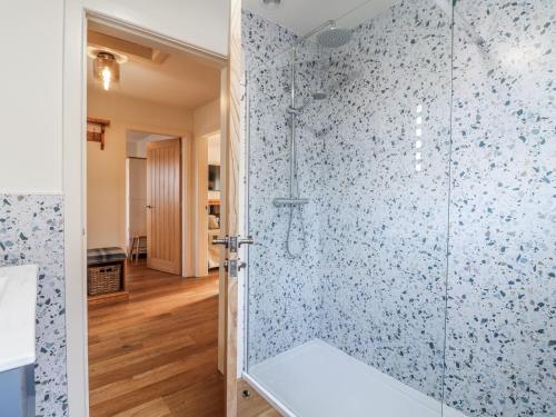 ein Badezimmer mit Dusche und blauen Fliesen in der Unterkunft Parkfields Cottage in Uttoxeter