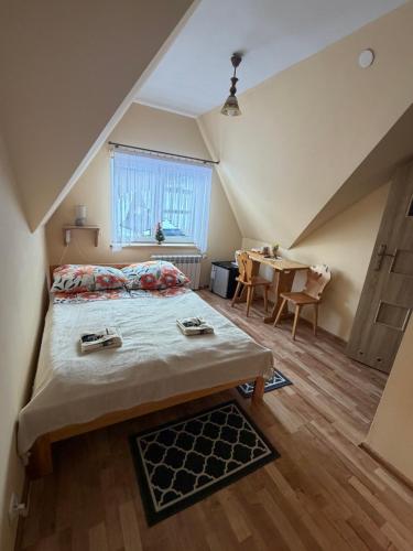 a small bedroom with a bed and a table at Pokoje "U Ani" in Leśnica