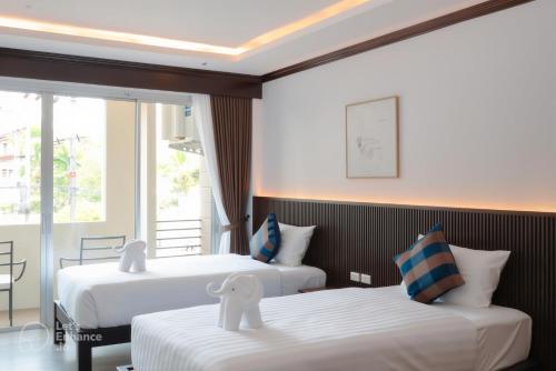 a hotel room with two beds and a window at Oh'tel Kata in Kata Beach