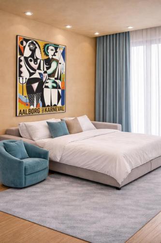 a bedroom with a large bed and a blue chair at FourSeasons - Carnival Summer Lounge in Aalborg