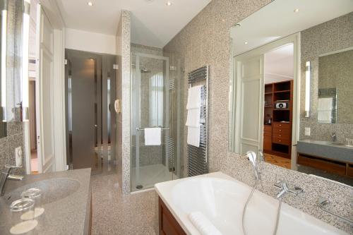a bathroom with a tub and a sink and a shower at La Résidence des Trois Couronnes in Vevey