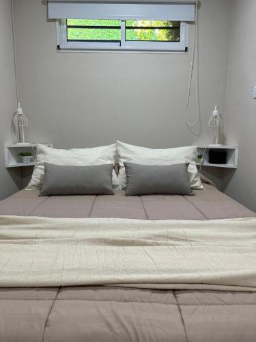 a large bed in a white room with a window at La quinta de Vito in San Pedro