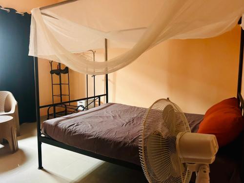a bedroom with a bed with a mosquito net at Chambre avec salle de bain privative proche de la plage et de Saly in Mbour