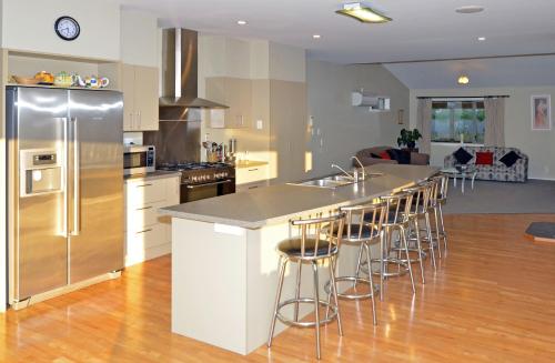a kitchen with a large island with bar stools at Hunters Moon in Mosgiel